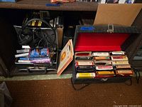 Overall view showing headphones, tape tray with cassettes, black 8-track case with red lining holding cartridges and vinyl sleeves