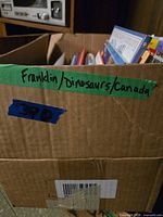 Box labeled Franklin/dinosaurs/Canada with books inside