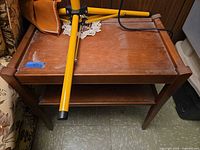 Top view of walnut veneer end table with open lower shelf