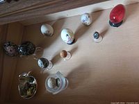 Drawer view showing assorted decorative eggs, stands and dish