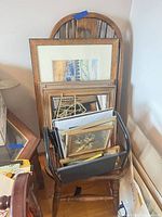 Group view of stacked framed prints, empty frames, brass easels and vinyl rack