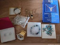 Overview of entire lot showing watches, bracelets, ring box, earrings box, and Blitz cloth