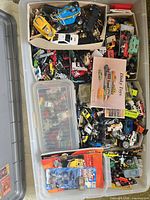 Large bin with bulk loose cars, Hot Wheels blister, Fast Wheel blister, Dinky Toys booklet visible
