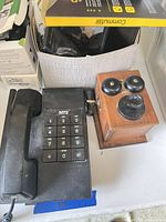 Black MTS desk phone, wooden novelty phone, box of accessories