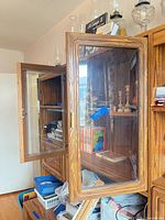 Left section detail with open glass door revealing interior shelving