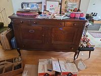 Full front view of oak sideboard buffet showing drawers, cabinet doors, legs, and overall finish