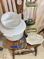 All items on chair including blender, bowls, glassware, plate and coaster