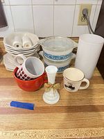 Group shot showing all items: stacked plates, two mugs, candle holder, vases, two Pyrex casseroles