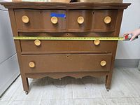 Front view showing all four drawers and tape measure for width