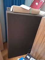 Front view of one floor speaker with brown grille