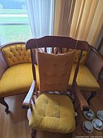 Rocking chair in front of two barrel-back chairs showing cushions and wood finish