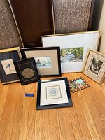 Group shot of seven framed artworks arranged on floor showing relative sizes and frame styles