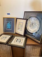 Group view of all five framed pieces on cabinet
