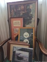 Overview of stacked framed prints on chair