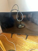 Front view of Sharp 32" Roku TV showing screen and attached legs