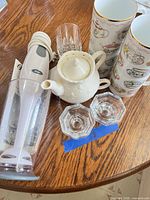 Tea-for-one set pieces with glass votives visible on tabletop