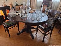 Pedestal dining table with chairs around, leaves in place