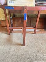 Underside and legs of cherry finish demilune side table showing leg shape and stretcher