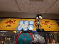 Overall lot showing three yellow alcohol price signs, sealed pack of blue/white Staycold cup holders, and novelty golf utensil/tee holder with golf balls and figurine