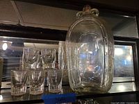 Bottle and shot glasses grouped together on shelf