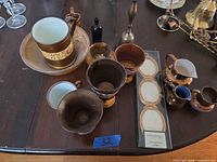 Overview showing teacup, saucer, goblets, creamers, bottle and bell