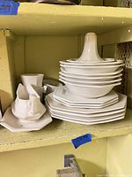 Stacked octagonal plates and bowls, gravy boat on undertray, small creamer, all white ironstone