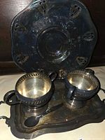 Tray, two handled cups and spoon displayed together