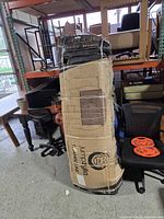 Full boxed trampoline standing upright, taped seams visible