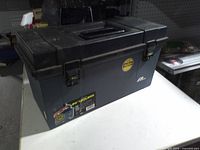 Front view of black plastic 20-inch toolbox with label and latches visible