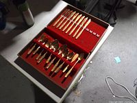 Flatware set in open case showing knives, spoons and forks