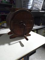 Front view showing barrel, crank handle and stand