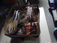 Full cardboard box filled with mixed CDs, Lucy Kaplansky title visible