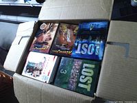 Open box showing Lost Seasons 3 & 4, Naruto box sets and other DVDs