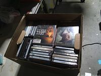 Open box showing stacks of sealed DVDs with visible title Sexy Beast