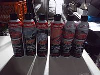 Front view of six Fastwax FW1 automotive cleaning aerosol cans displaying product types