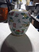 Full view of ginger jar with lid displaying painted motifs and shape