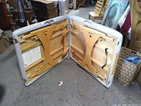 Massage table opened showing wooden frame, cable supports