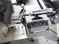 Top view of Hermes 10 electric typewriter, dust cover, manual