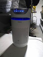 Front view of white HoMedics tower air purifier showing control panel and blue light band