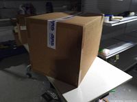 Sealed brown box on table, full view