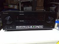 Front view showing Pioneer branding, display, control knobs and feature icons