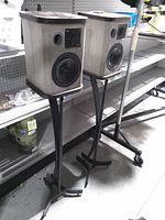 Two Rauna Tyr II bookshelf speakers on metal stands