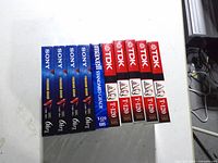 Front view of all ten sealed VHS tapes showing brands and model