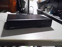 Front view showing Sanyo branding, disc tray, display and buttons