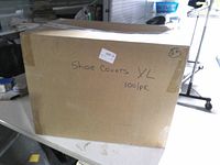 Front of sealed box labeled 'Shoe Covers XL 100/pk'