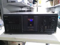 Front view of Sony 300-disc CD changer with display, controls and disc slot