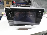 Front view of Subaru OEM touchscreen head unit showing display, knobs and buttons