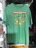 Front view of green TMNT graphic T-shirt on hanger