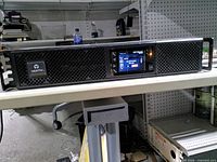 Front view showing Vertiv logo, mesh grille, LCD display illuminated