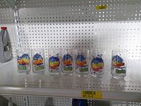 All seven Diet Pepsi glasses lined on shelf